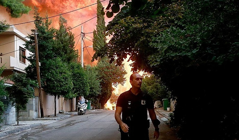 Φωτιά Βαρυπόμπη: Αστυνομικοί προσπαθούν να σπάσουν πόρτα αναζητώντας εγκλωβισμένους
