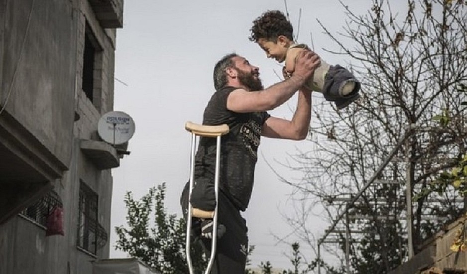 Η φωτογραφία της χρονιάς: Η συγκλονιστική εικόνα πατέρα και γιου με φόντο τον πόλεμο στη Συρία