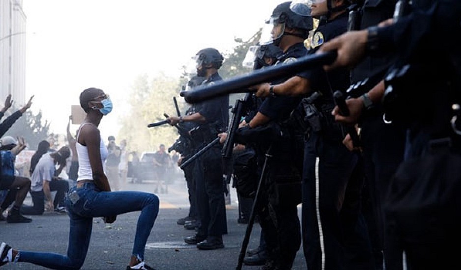 Μαύρη διαδηλώτρια γονατίζει μπροστά σε τείχος αστυνομικών - Η εικόνα που έγινε viral