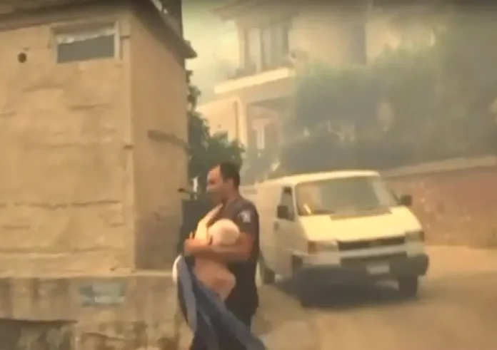 Συγκλονιστικό βίντεο από την Πάτρα: Αστυνομικός παίρνει στα χέρια ηλικιωμένο για να τον απομακρύνει από τη φωτιά